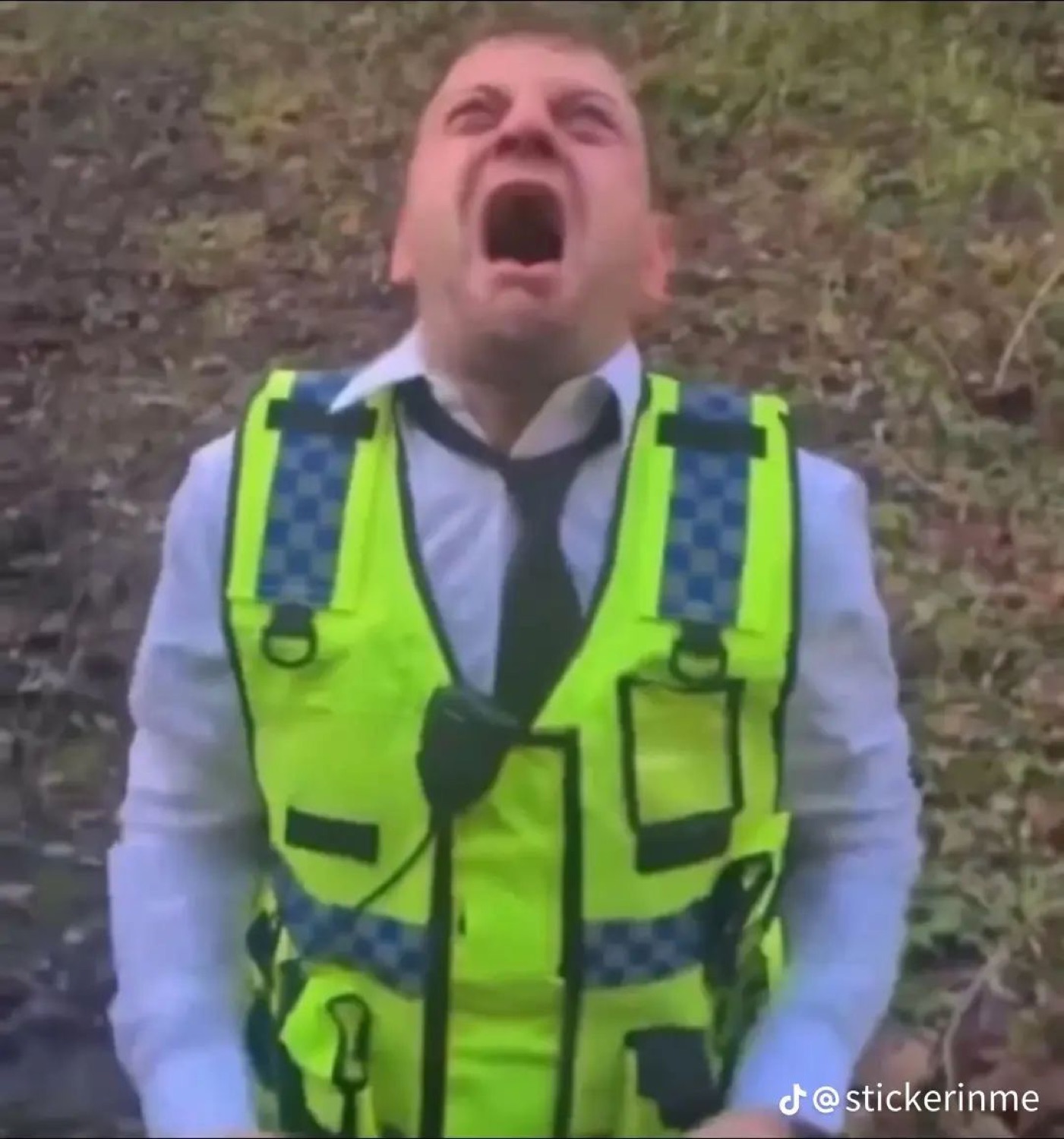 Man in a hi-vis vest tilts his head back and screams into the sky