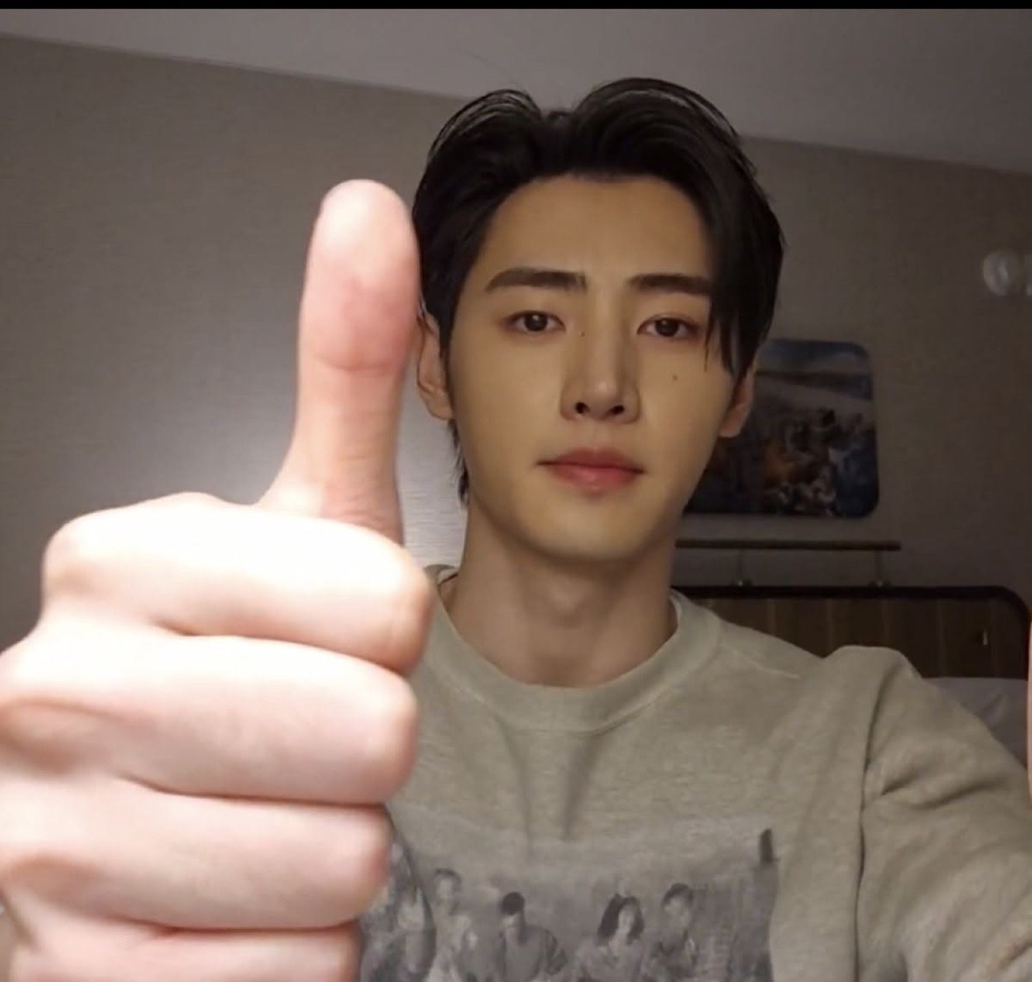Young man giving a deadpan thumbs up close to the camera