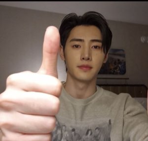 Young man giving a deadpan thumbs up close to the camera