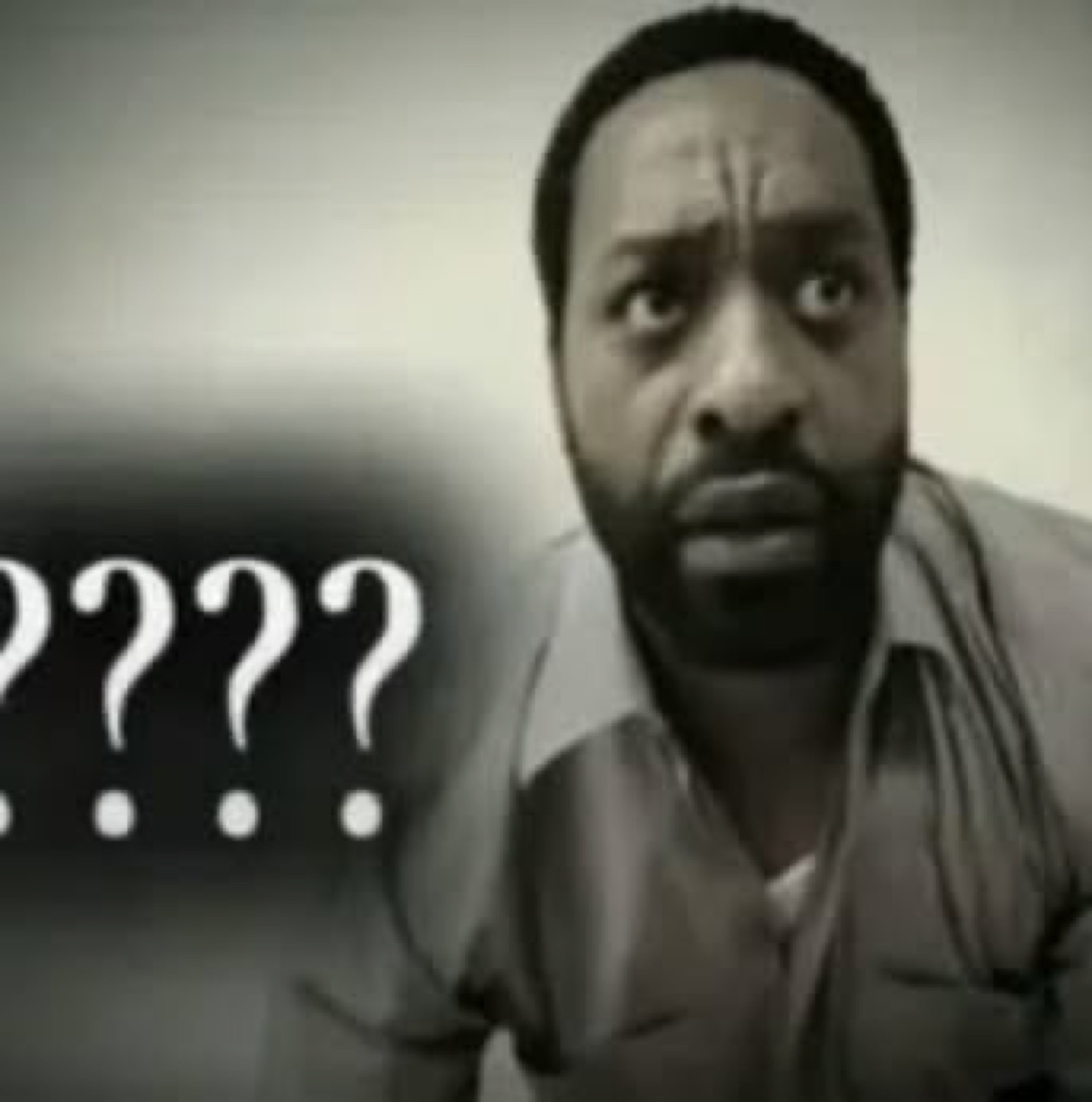 Man staring sideways with furrowed brow next to floating question marks