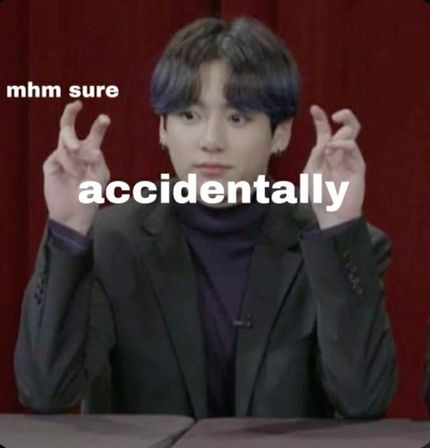 K-pop idol making air quotes with 'mhm sure' and 'accidentally' overlaid in knowing sarcasm