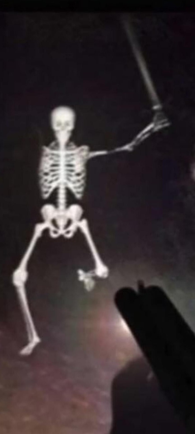 Skeleton waving and walking down a dark road at night