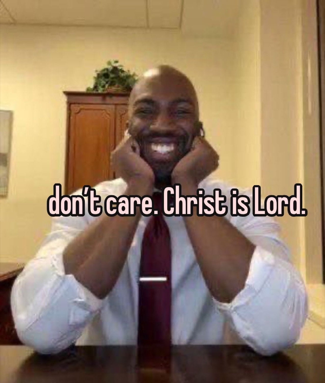 Smiling man resting his face in his hands: 'don't care. Christ is Lord.'
