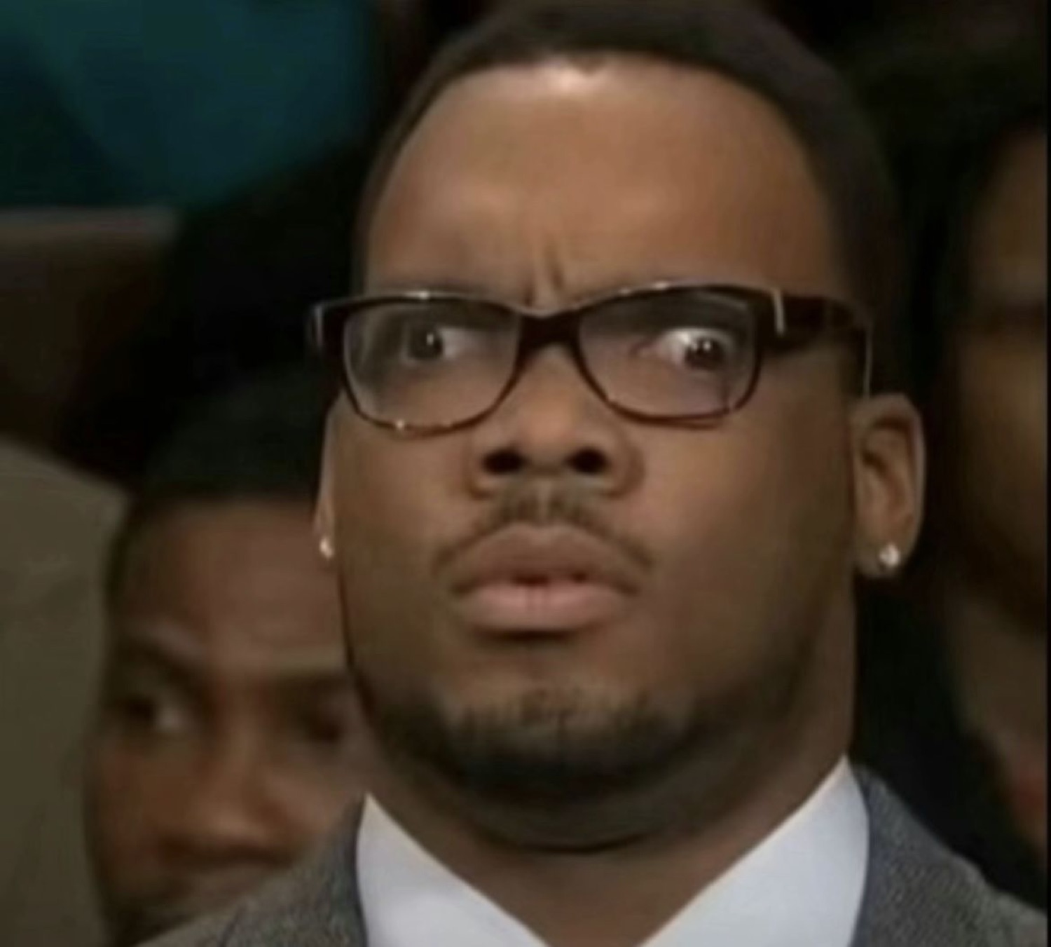 Man in thick-rimmed glasses with eyes wide, frozen in total disbelief