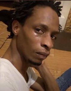 Man resting his chin on his hand with teary eyes, looking heartbroken and defeated