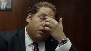 Man in a suit pinching the bridge of his nose in exhausted disbelief