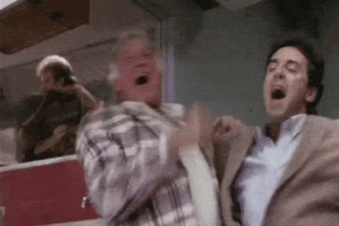 Two men in the stands screaming and pumping their fists in celebration