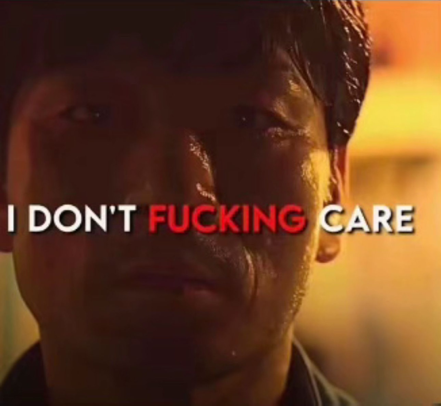 Shadowy close-up of a man's face captioned 'I DON'T FUCKING CARE' in red and white