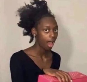Girl with a messy ponytail caught mid-reaction with her tongue out and a stunned face