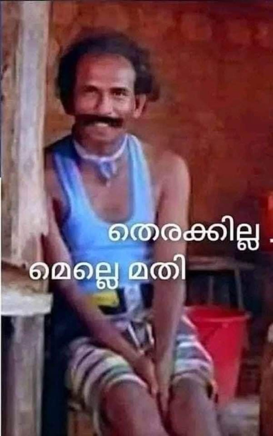 Thin man sitting on a stool: 'തെരക്കില്ല. മെല്ലെ മതി' (no rush, take it slow)