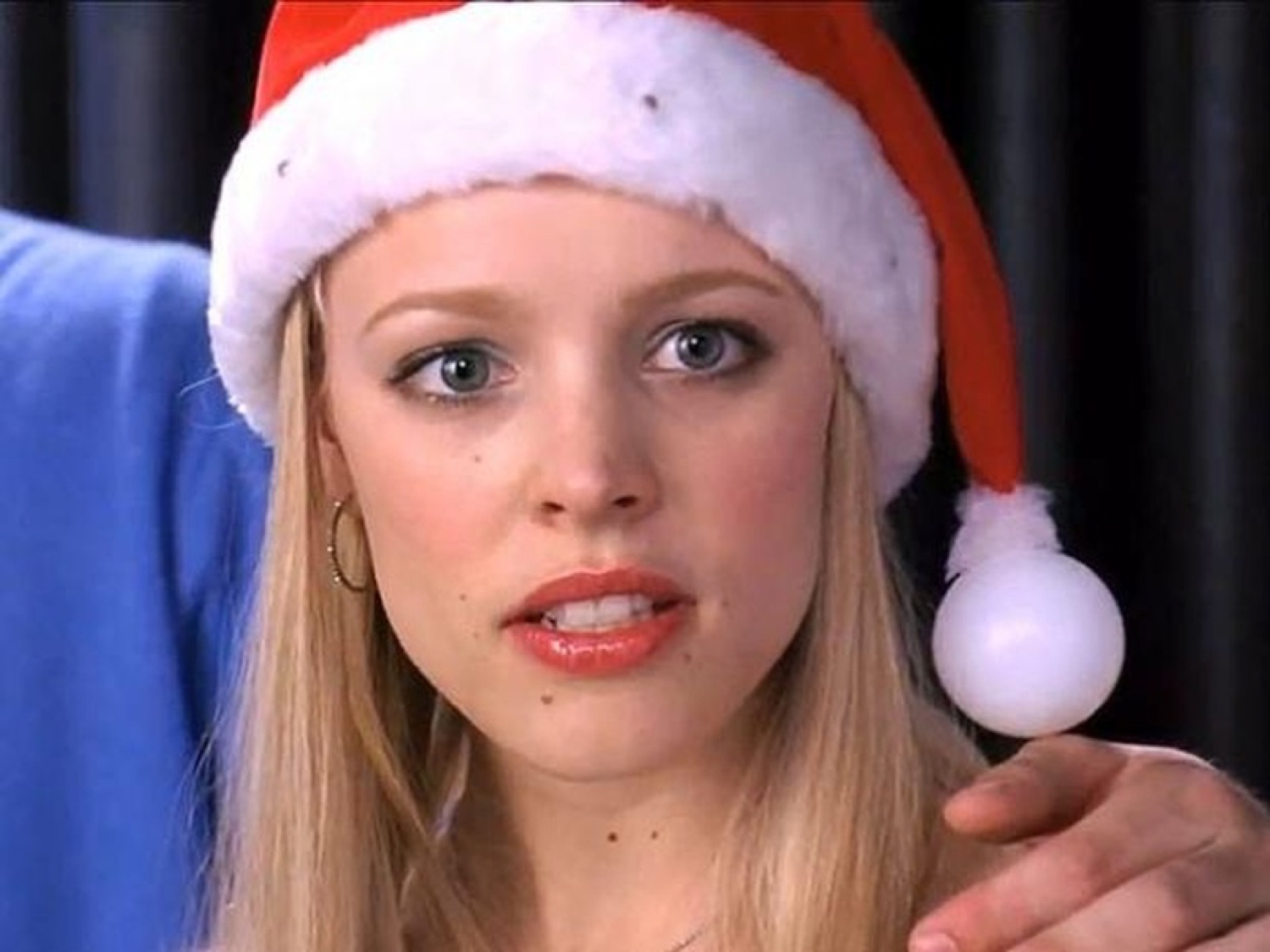 Blonde girl in a Santa hat staring straight ahead with a flat, unimpressed look