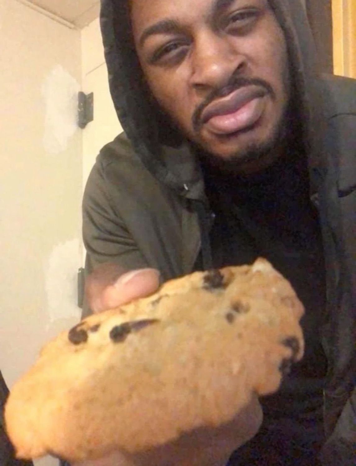Man holding a cookie with a disgusted look
