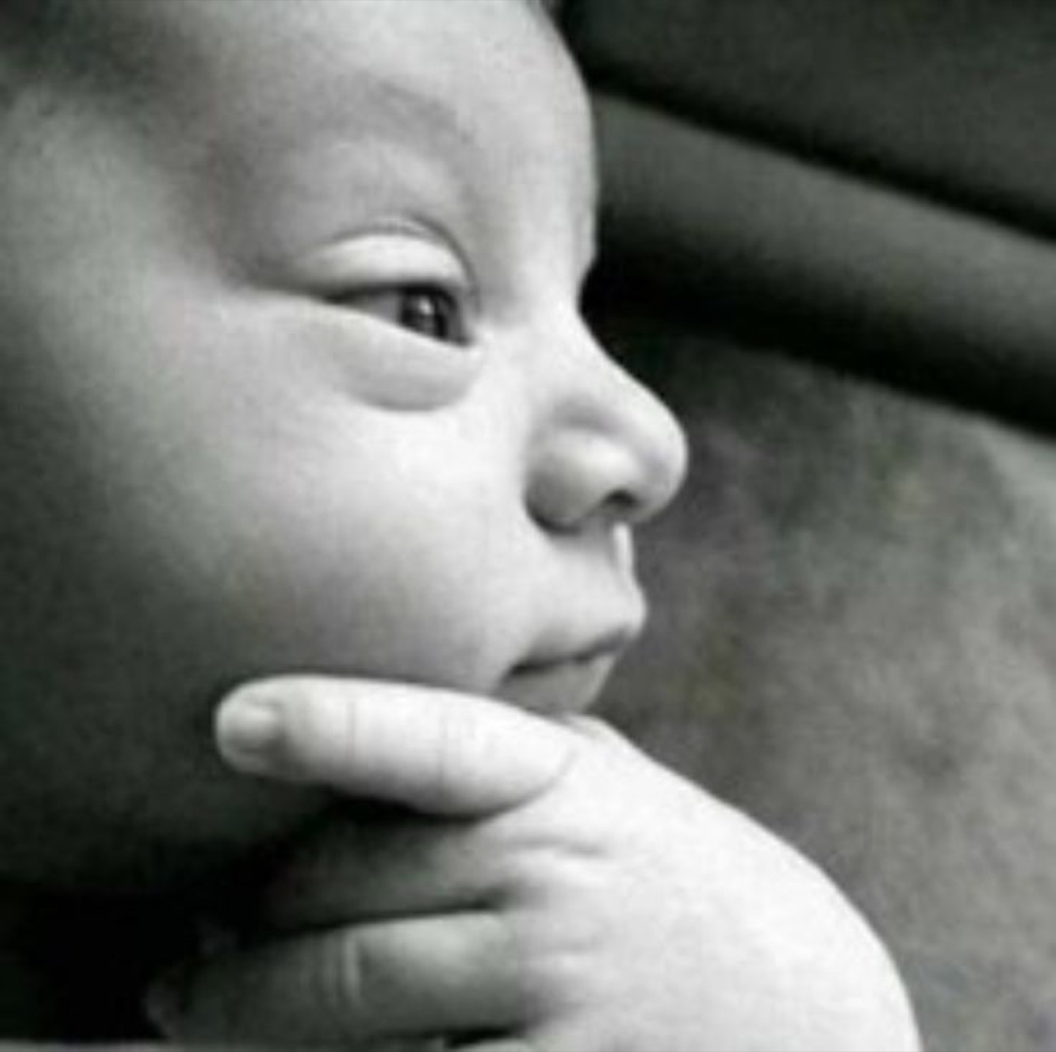 Black-and-white baby with a hand on its chin, thinking
