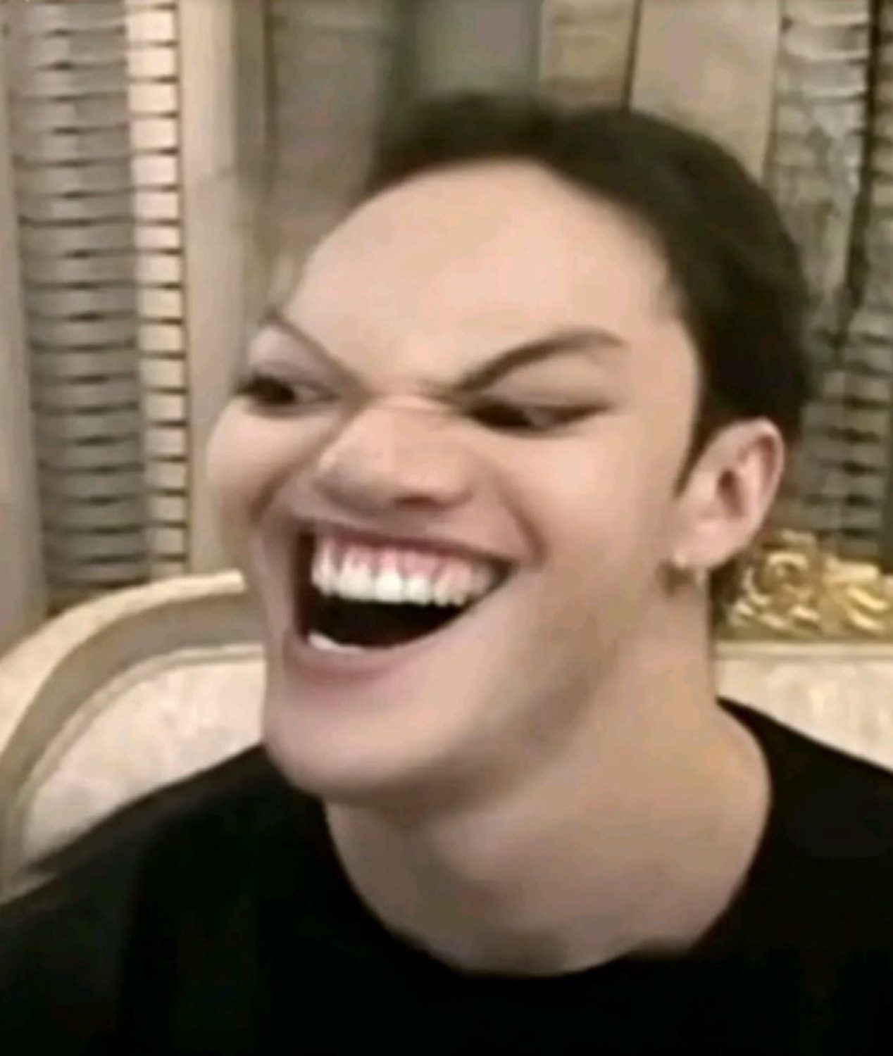 Person with an intensely furrowed brow laughing wide open with an almost unhinged grin