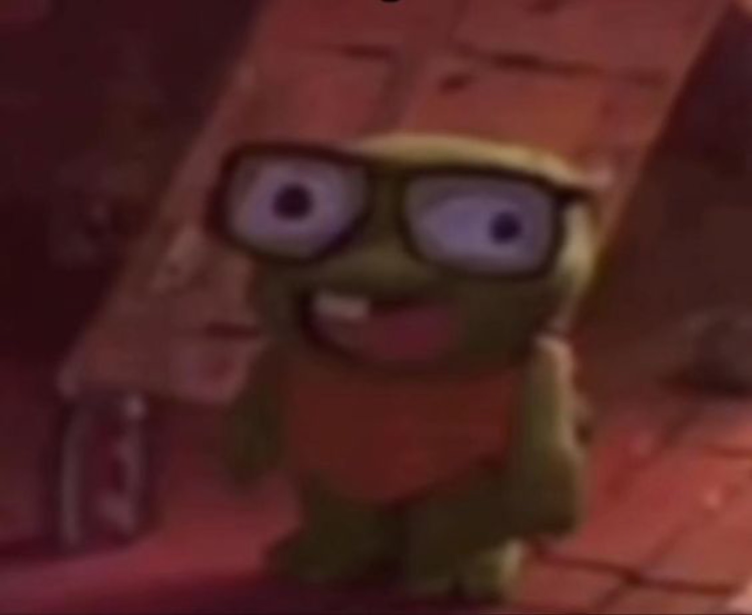 Blurry little CGI creature in thick glasses grinning with buck teeth