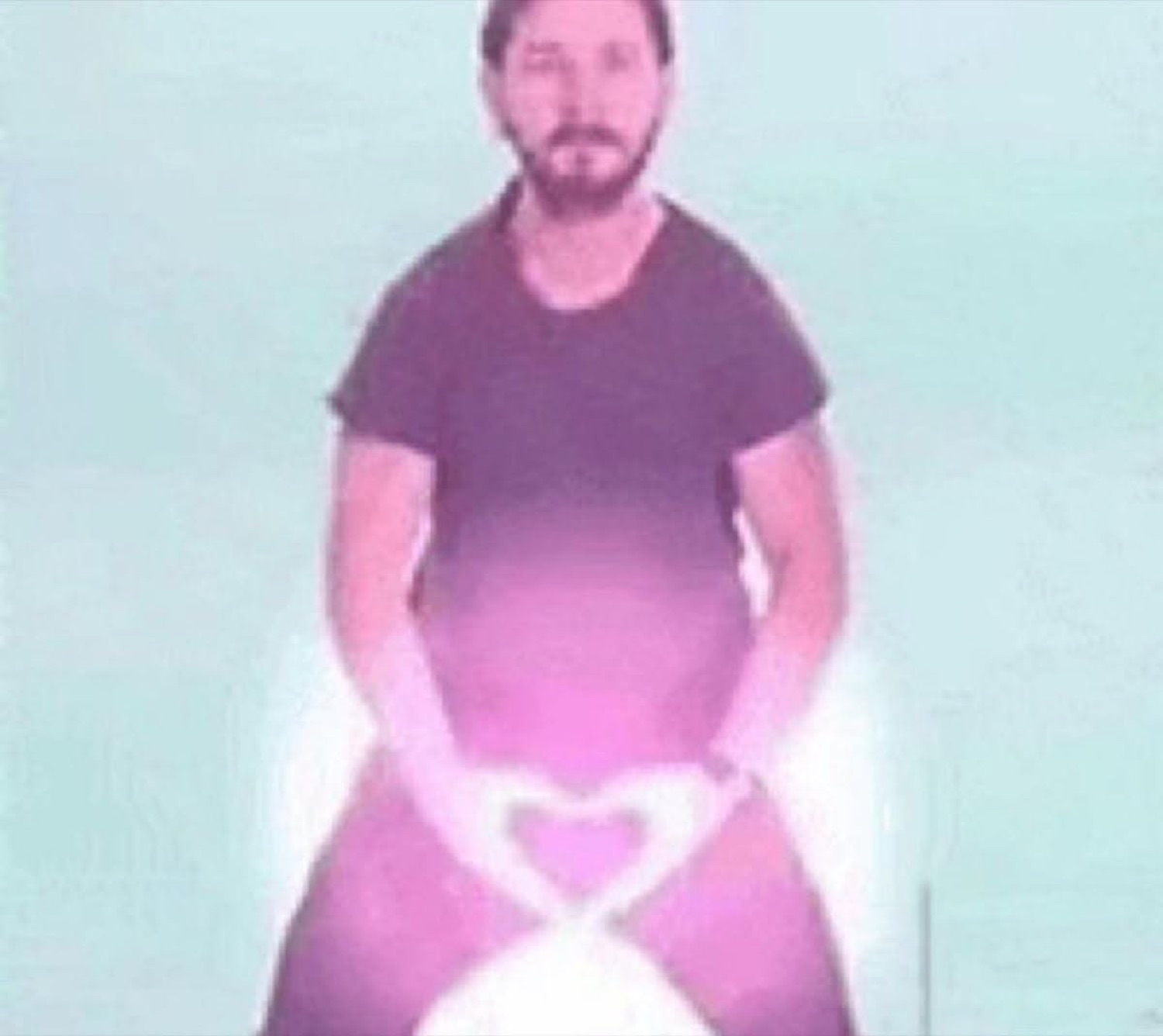 Bearded man in a purple-tinted green-screen clip making a heart shape with his hands
