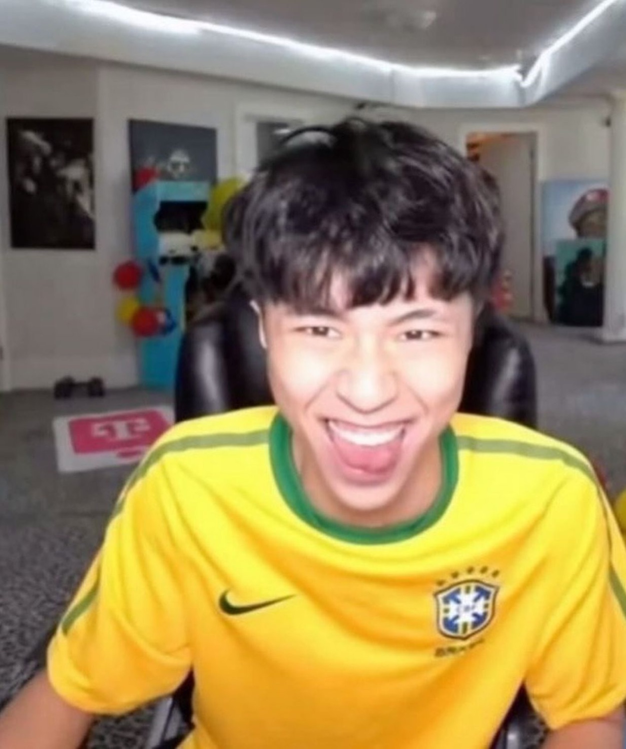 Streamer in a Brazil jersey beaming ear to ear at his webcam