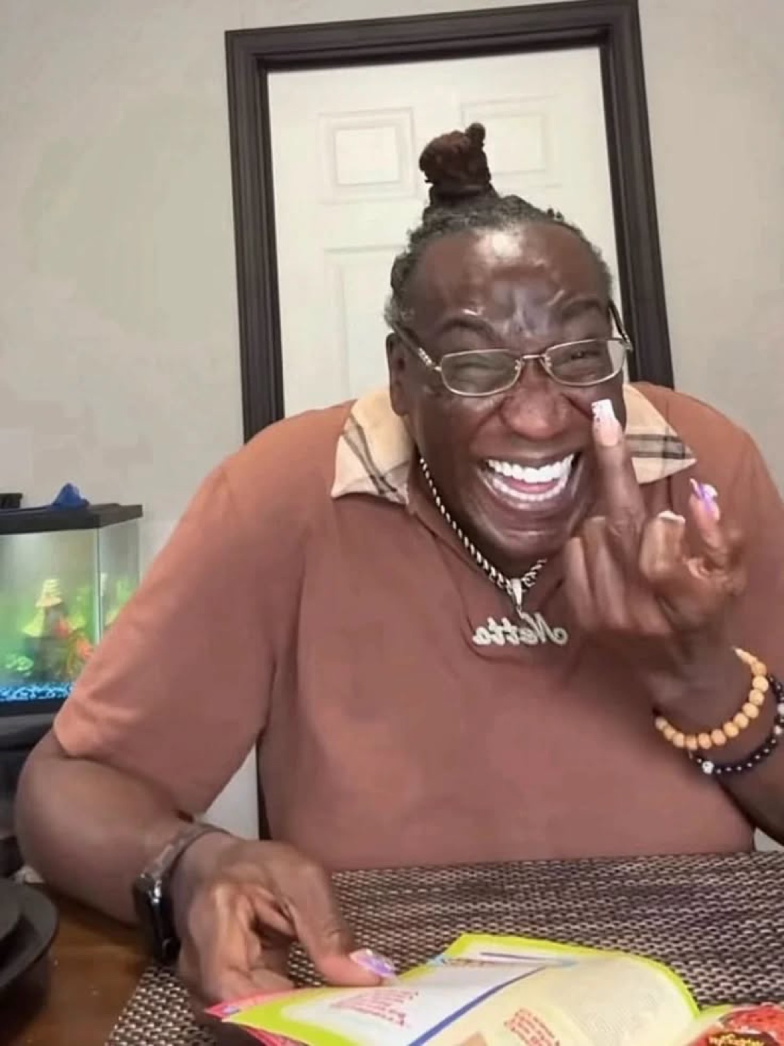 Man laughing loudly with a big grin, pointing playfully at the camera