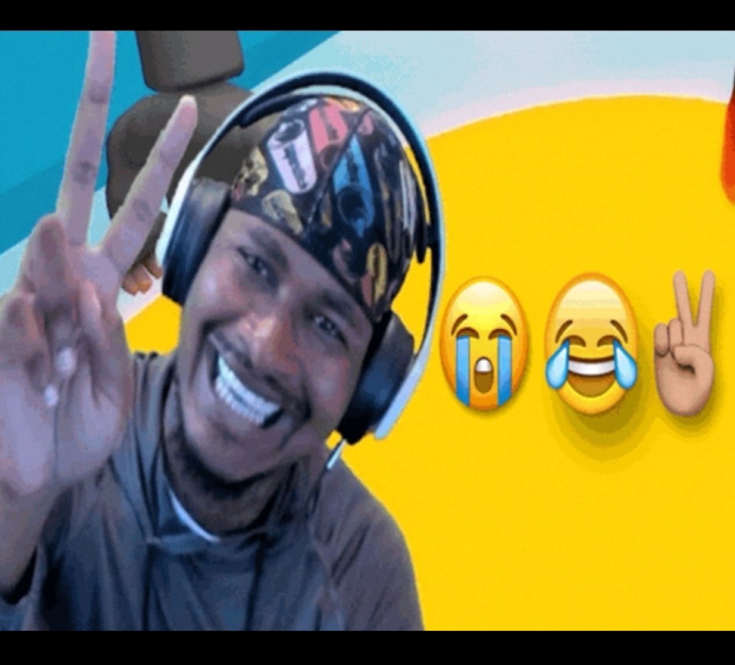 Streamer in headphones beaming and throwing a peace sign next to laughing emojis