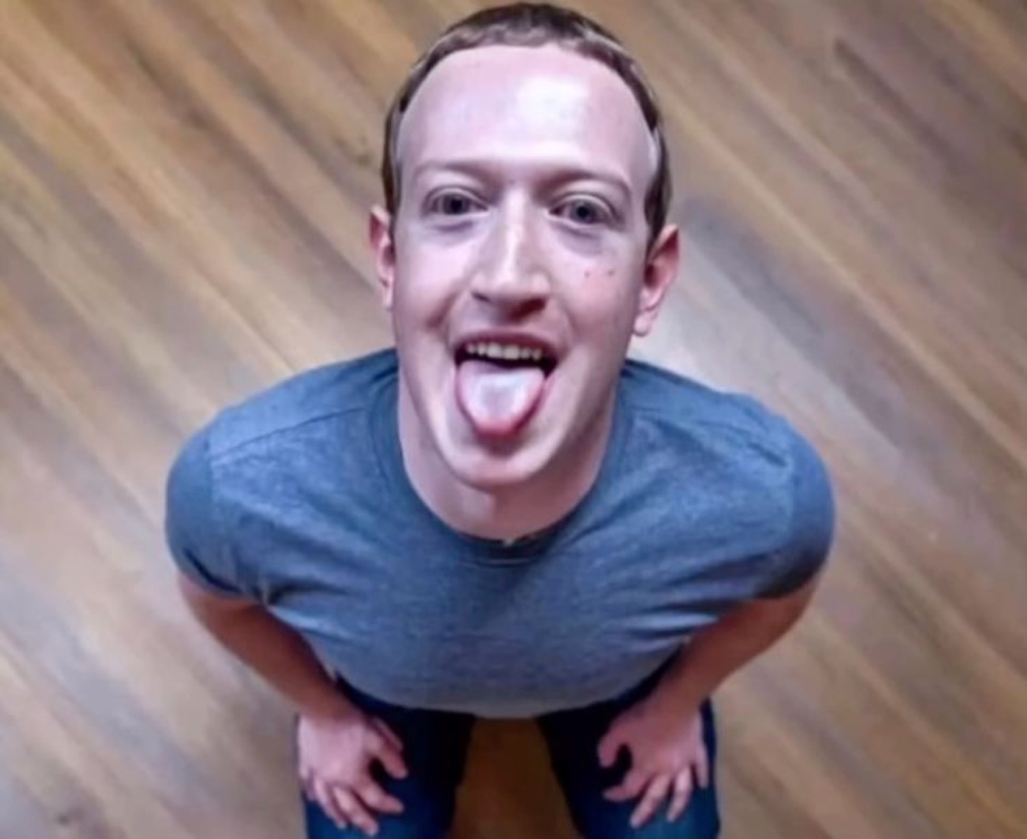 Mark Zuckerberg hunched over the camera with his tongue sticking out