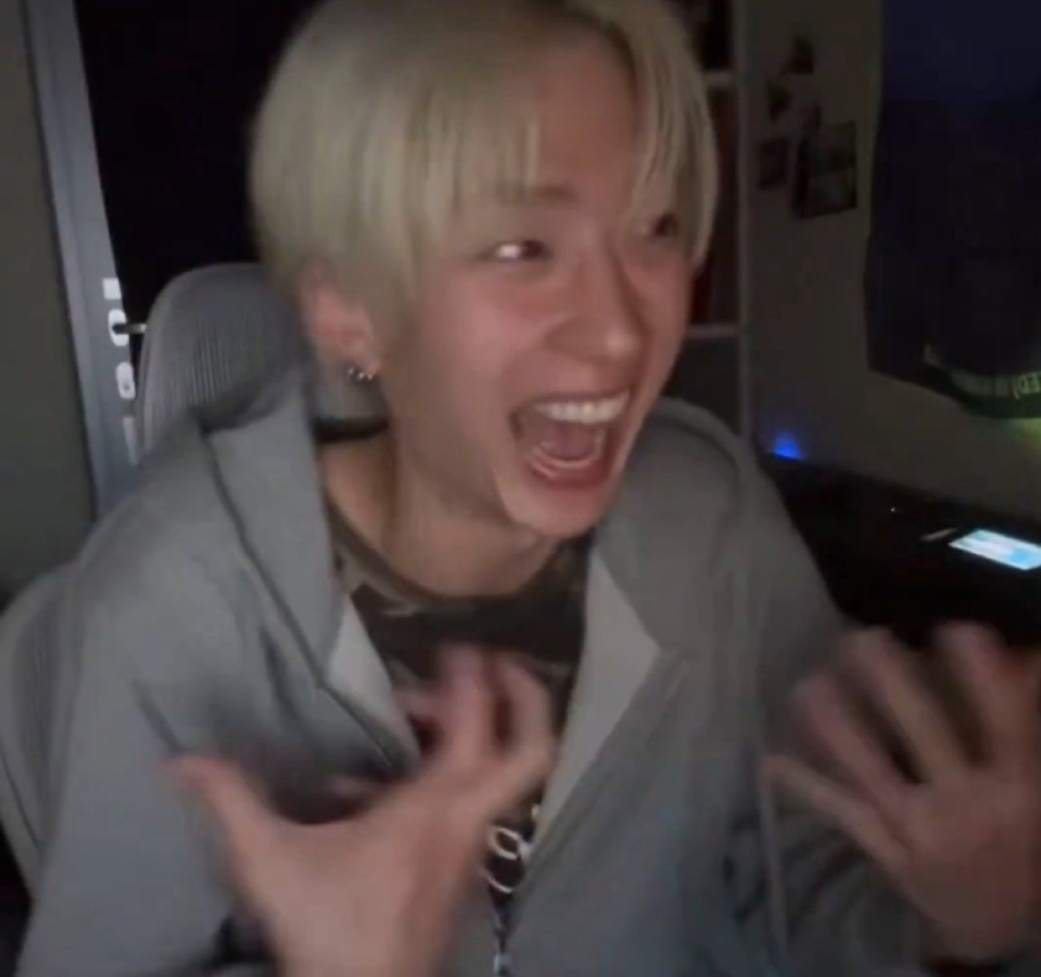 Blonde-haired guy at his desk screaming with both hands up in pure hype