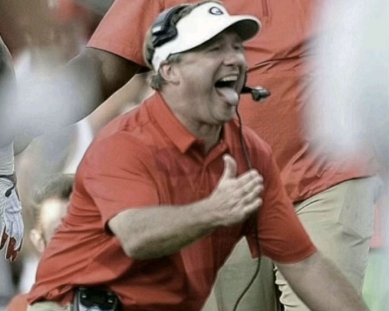 Football coach on the sideline screaming with open arms in full celebration mode