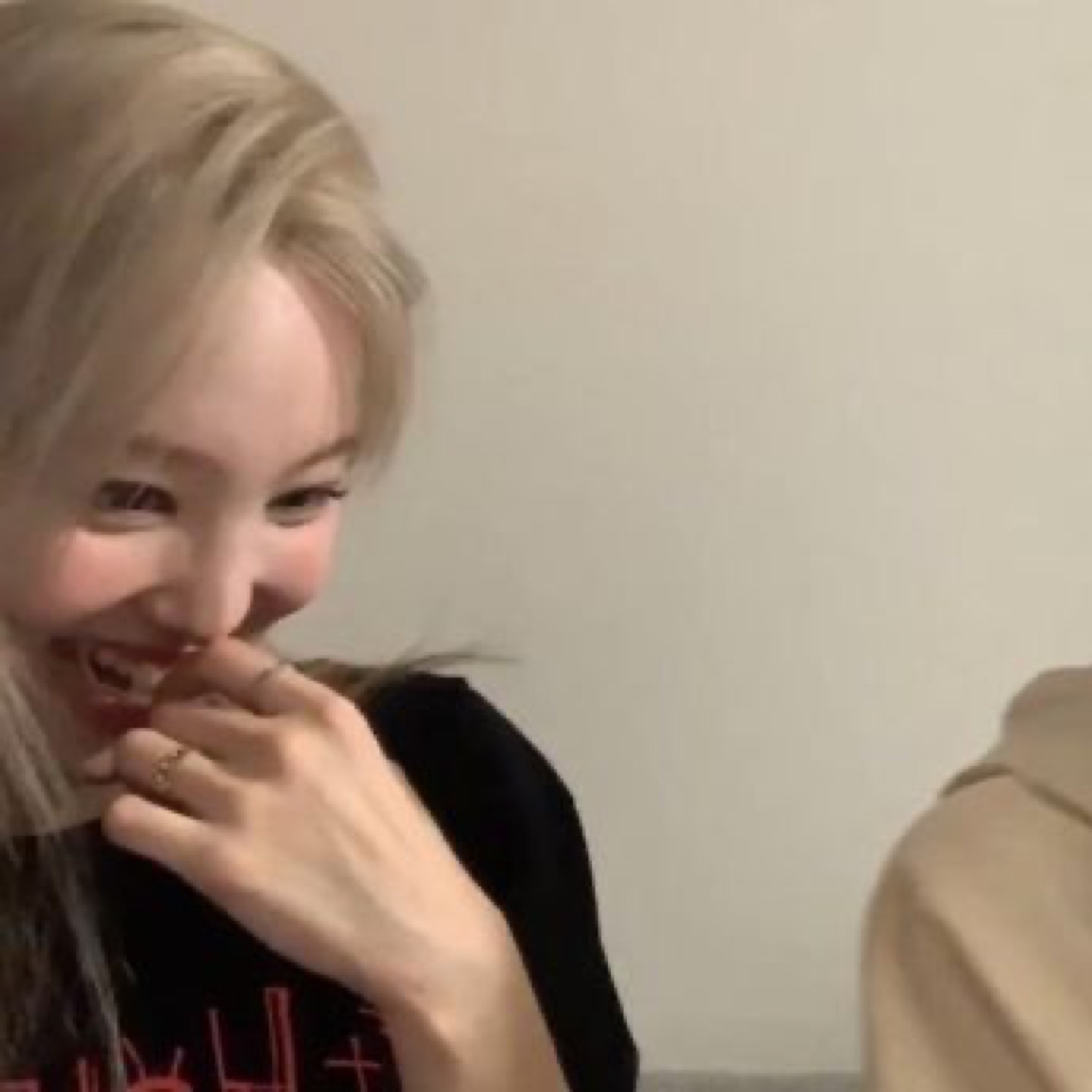 Blonde woman covering her mouth while laughing hard