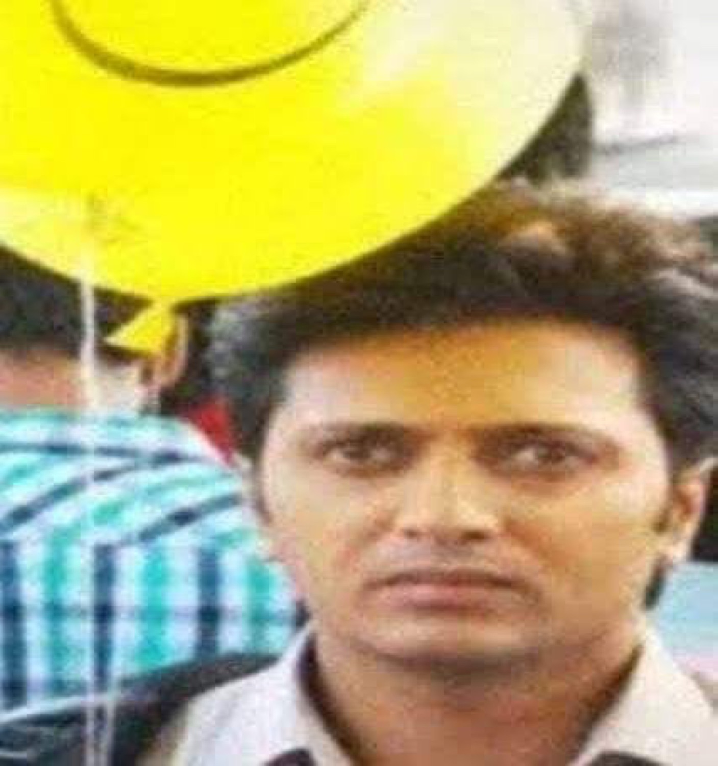 Riteish Deshmukh staring with a blank, worried face under a yellow umbrella