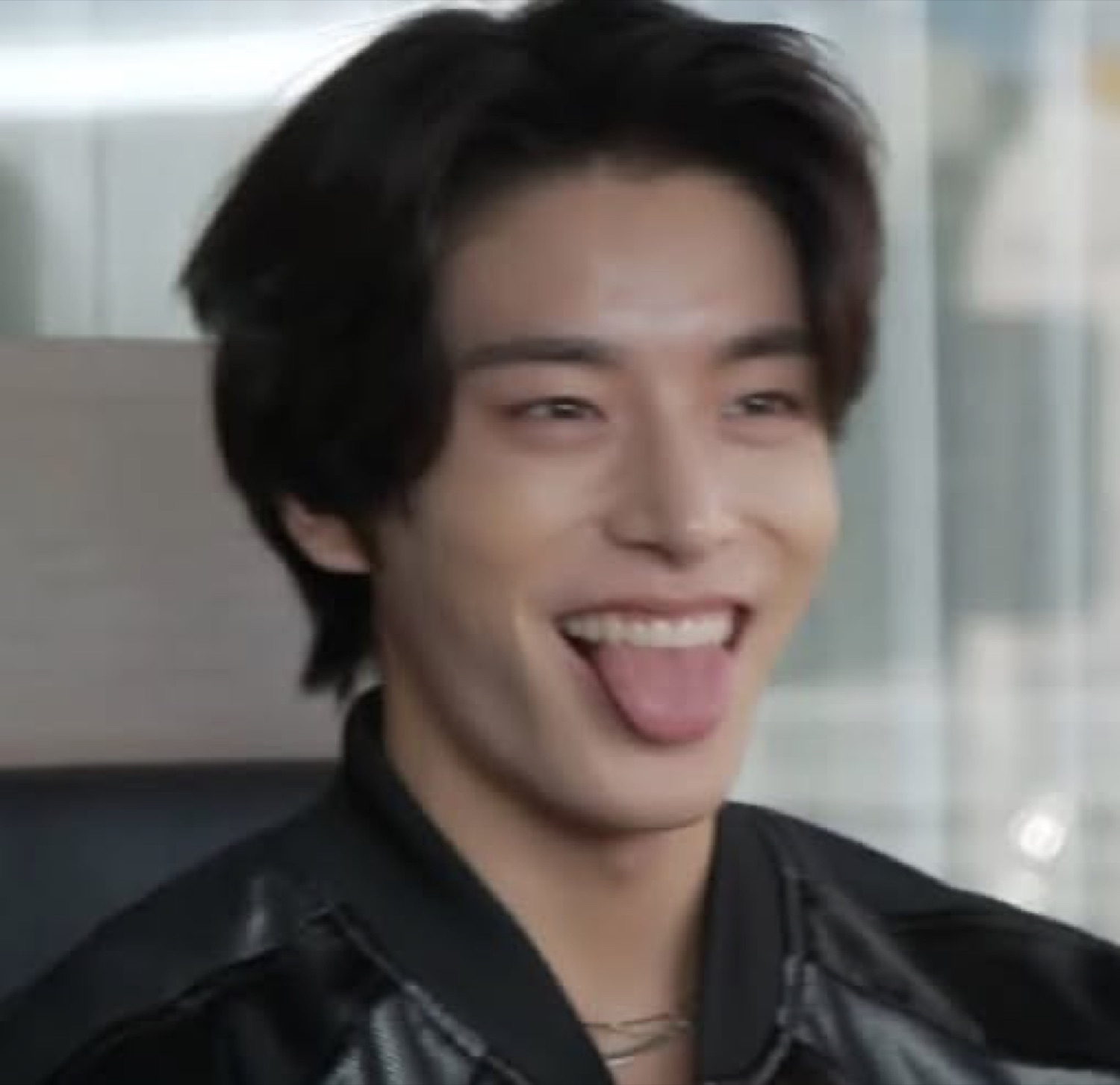 Guy in a leather jacket cackling with his tongue stuck out