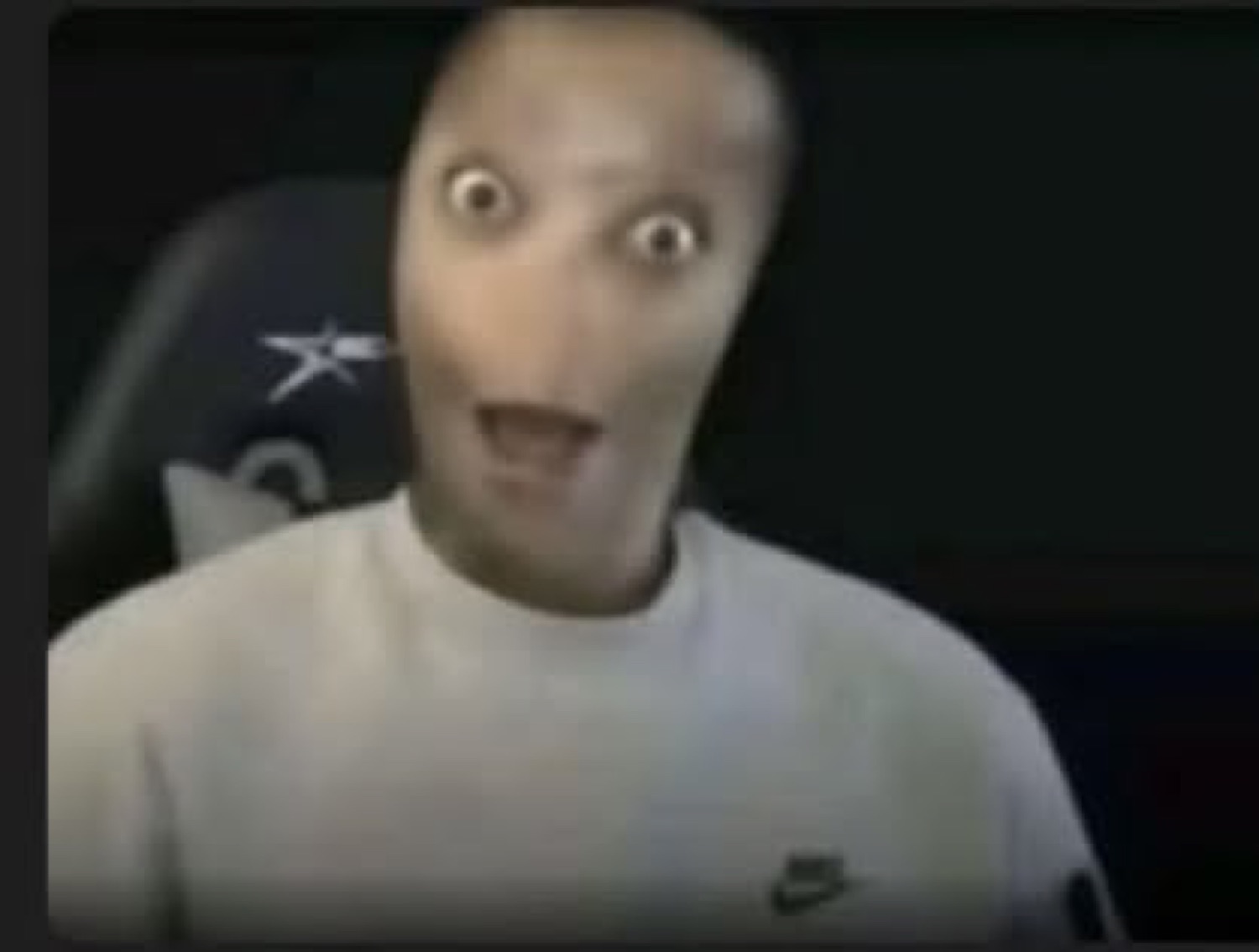 Distorted face with bulging eyes in a gaming chair