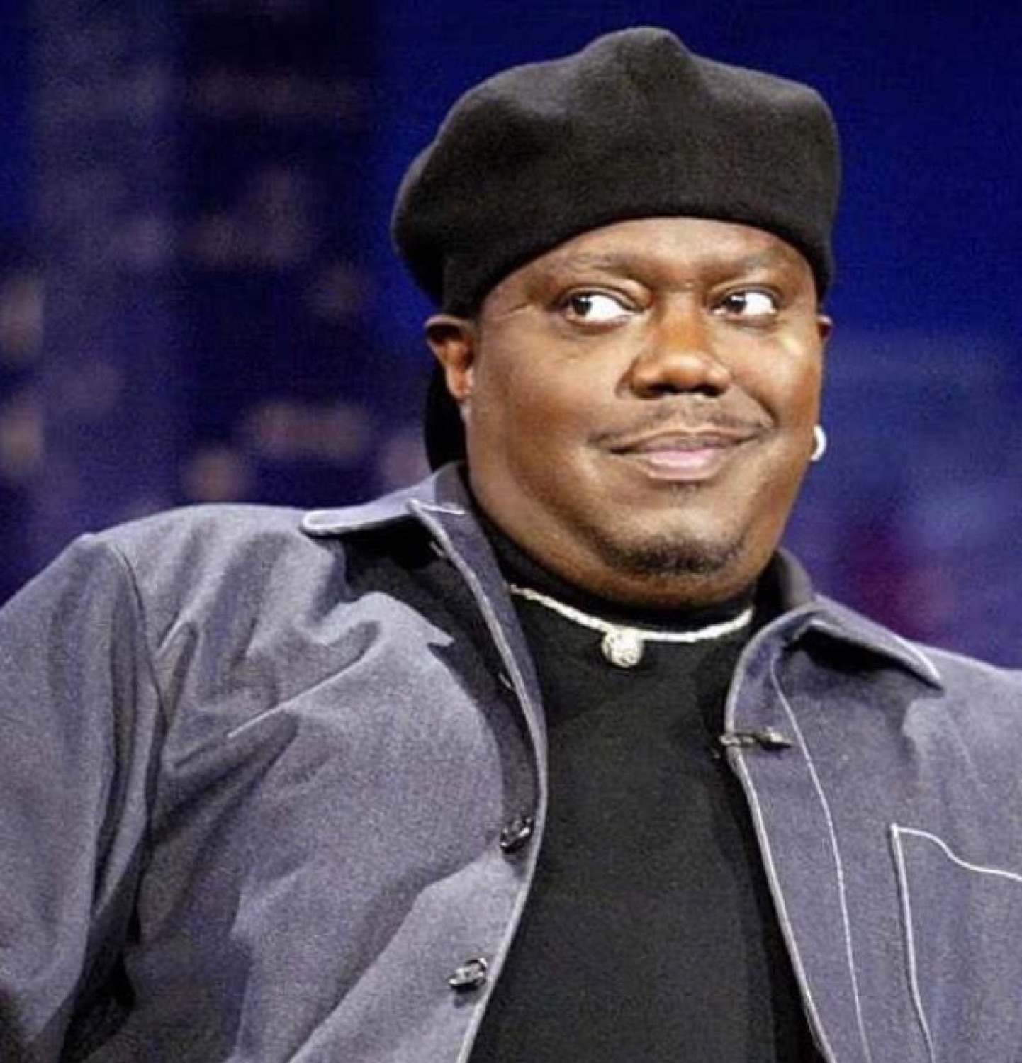 Bernie Mac in a beret giving a sly, knowing smirk