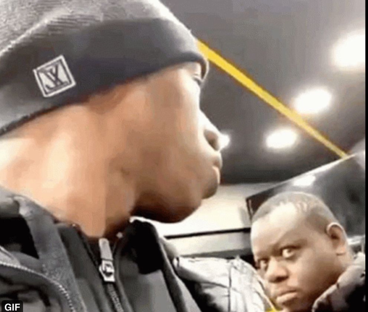 Man on a bus throwing a hard side-eye at the guy behind him