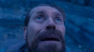 Bearded man lying back and gazing upward with a stunned, awestruck stare