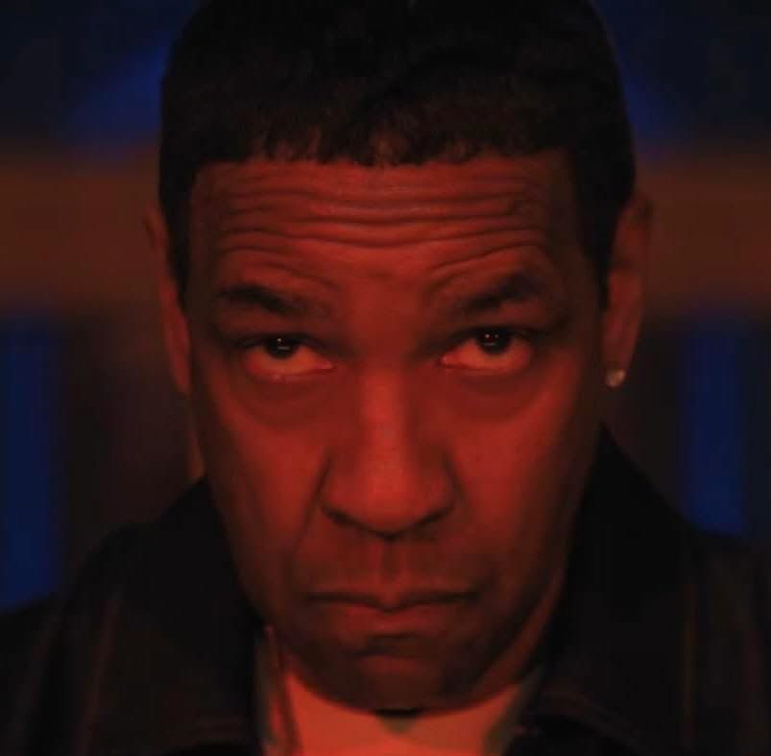 Denzel Washington staring dead into the camera with intense red-lit menace