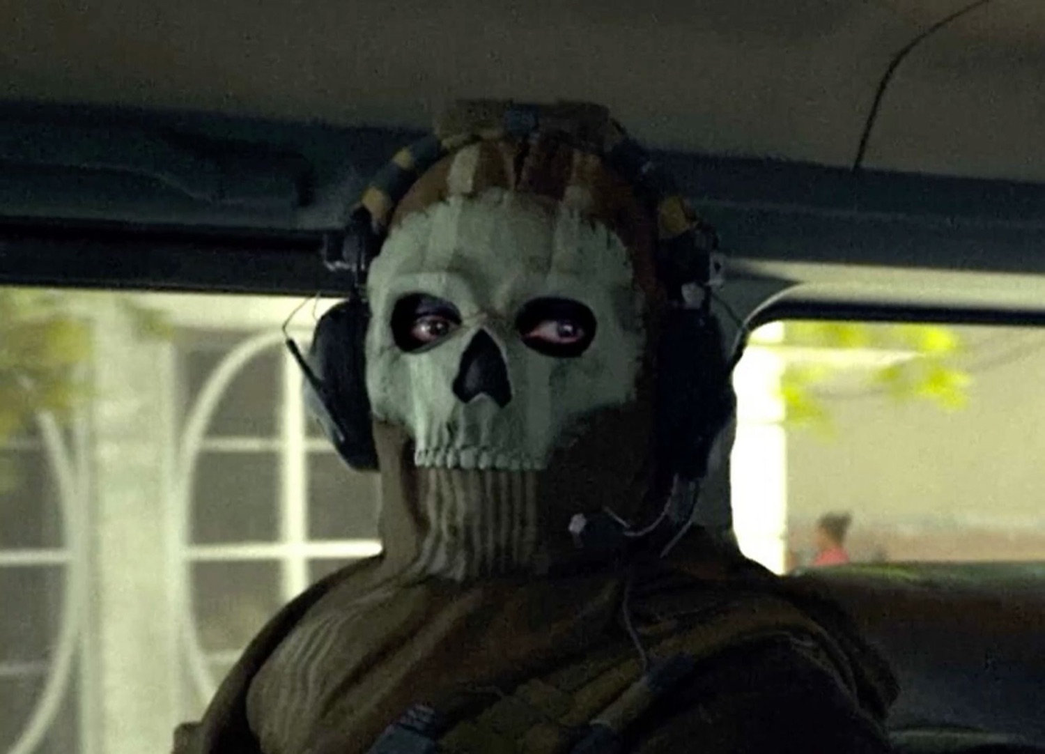 Call of Duty's Ghost in his skull mask staring blankly from inside a vehicle
