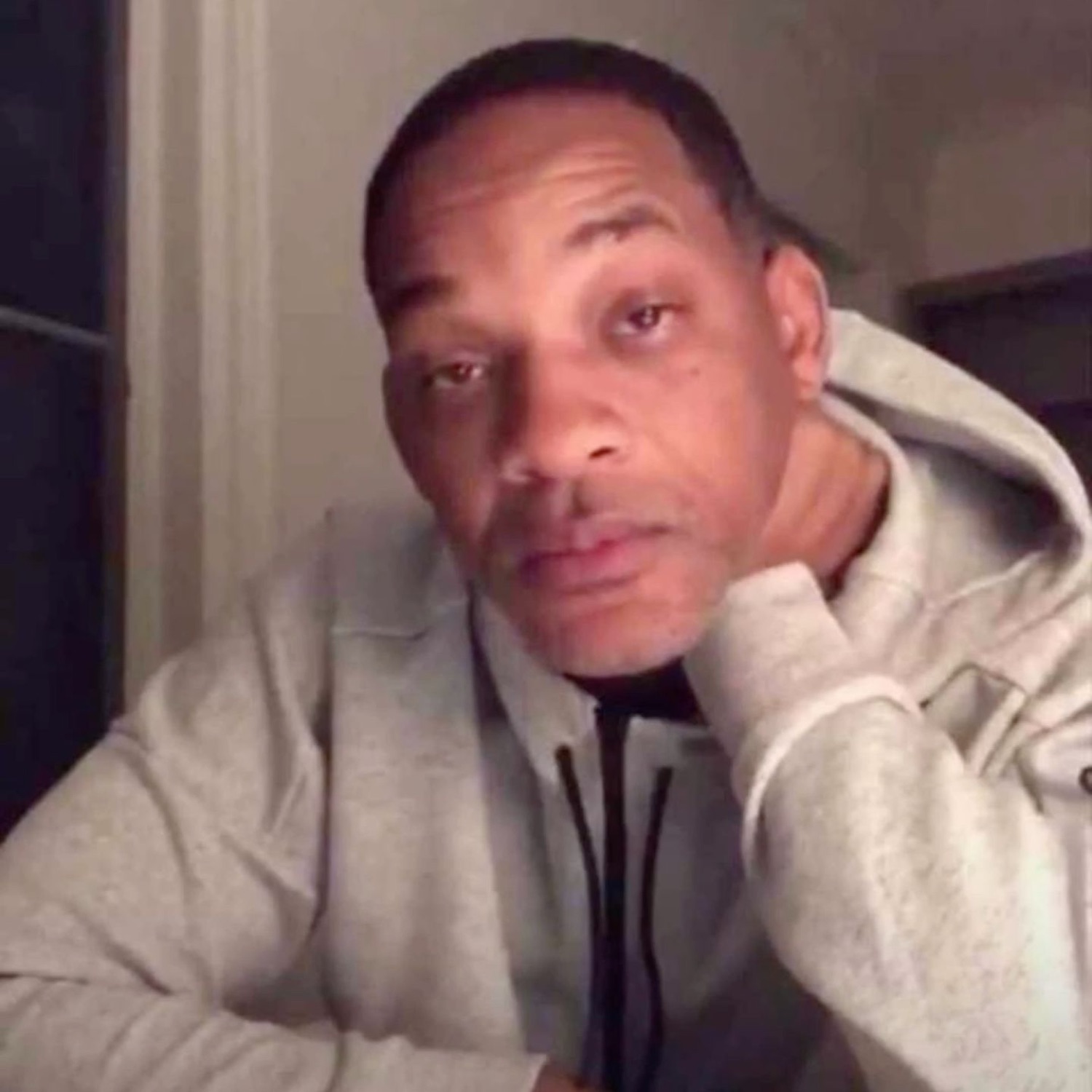 Man resting his chin on his hand, staring at the camera with a flat deadpan look