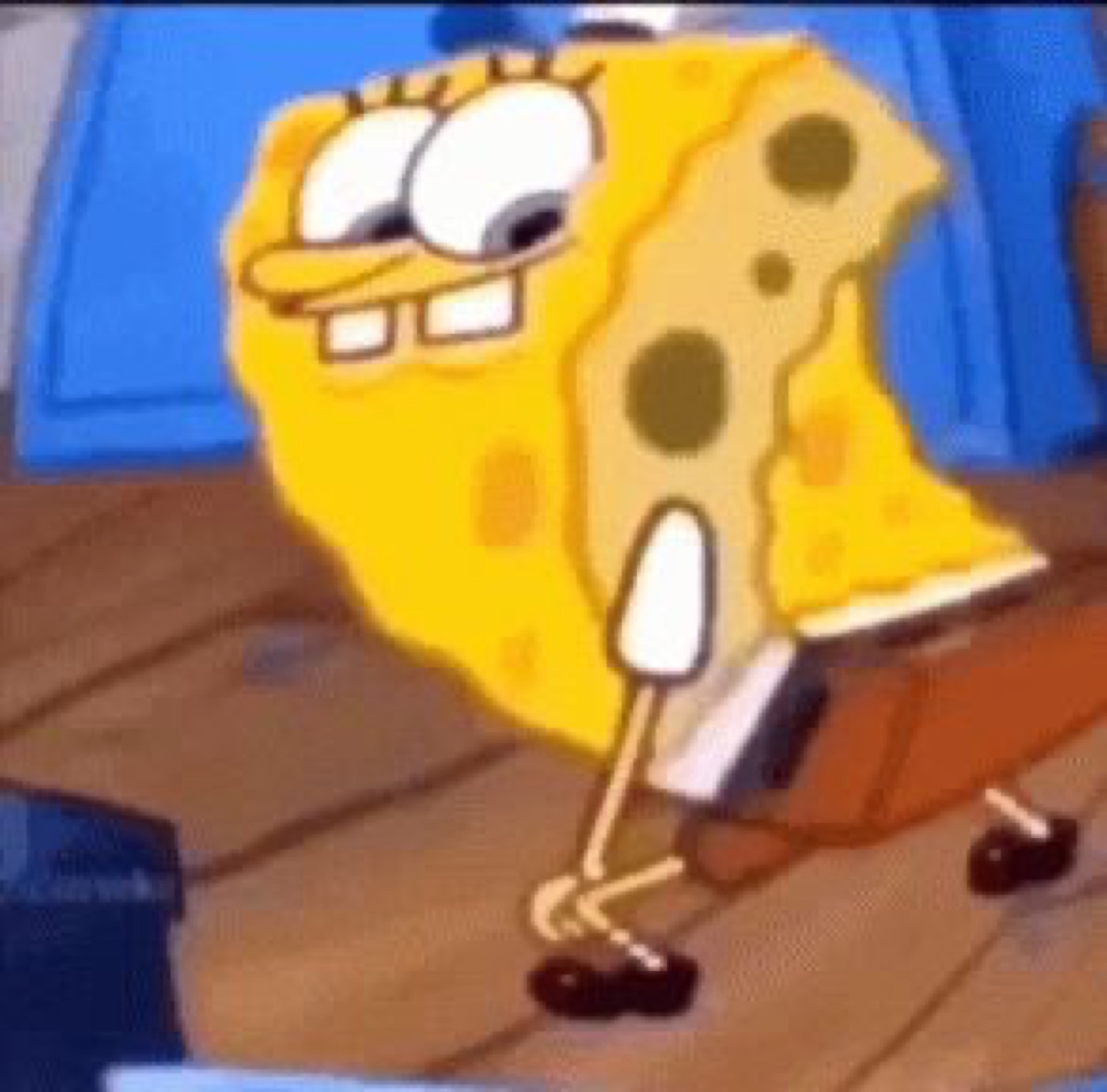 SpongeBob wiggling on the floor with a goofy grin