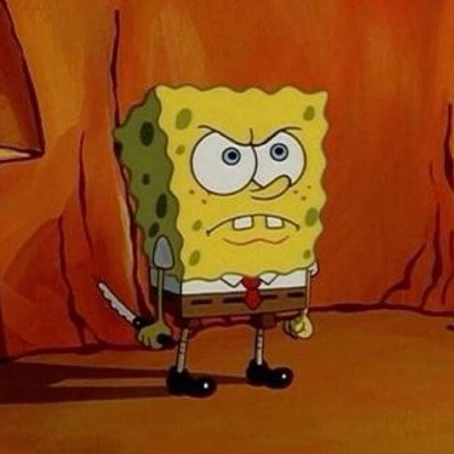 SpongeBob standing in an orange canyon with a furious clenched-teeth glare