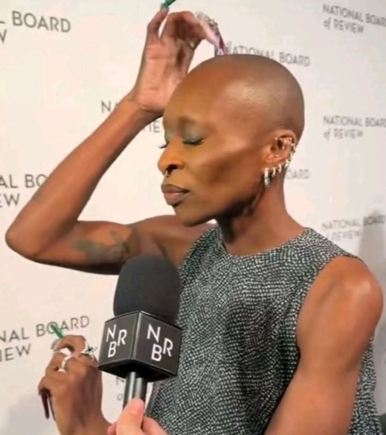 Bald woman at the National Board of Review event casually pretending to flip nonexistent hair