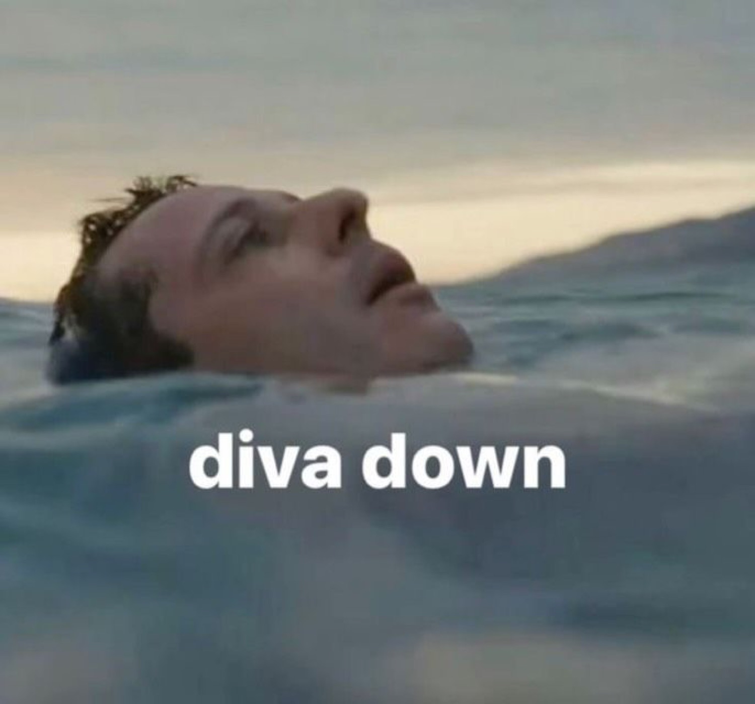 Man floating face-up in the ocean, eyes closed, captioned 'diva down'