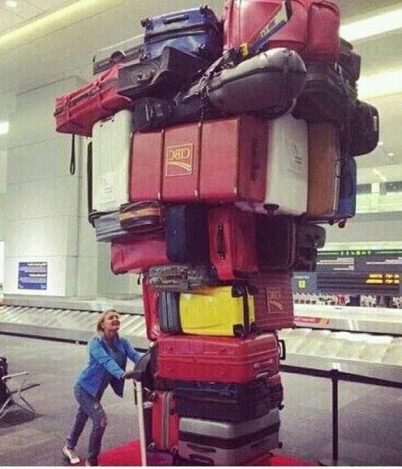 Person pushing a teetering tower of suitcases at the airport