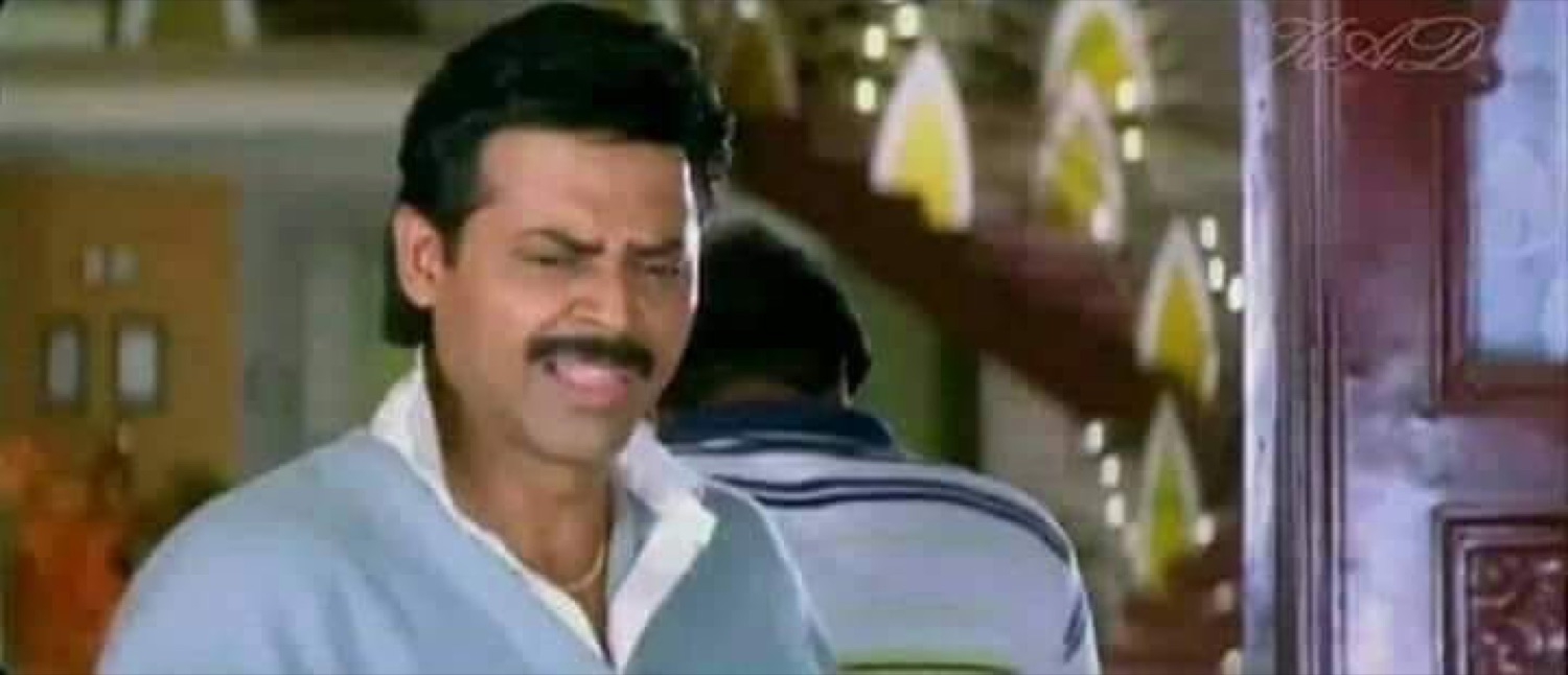 Venkatesh wincing awkwardly in a doorway