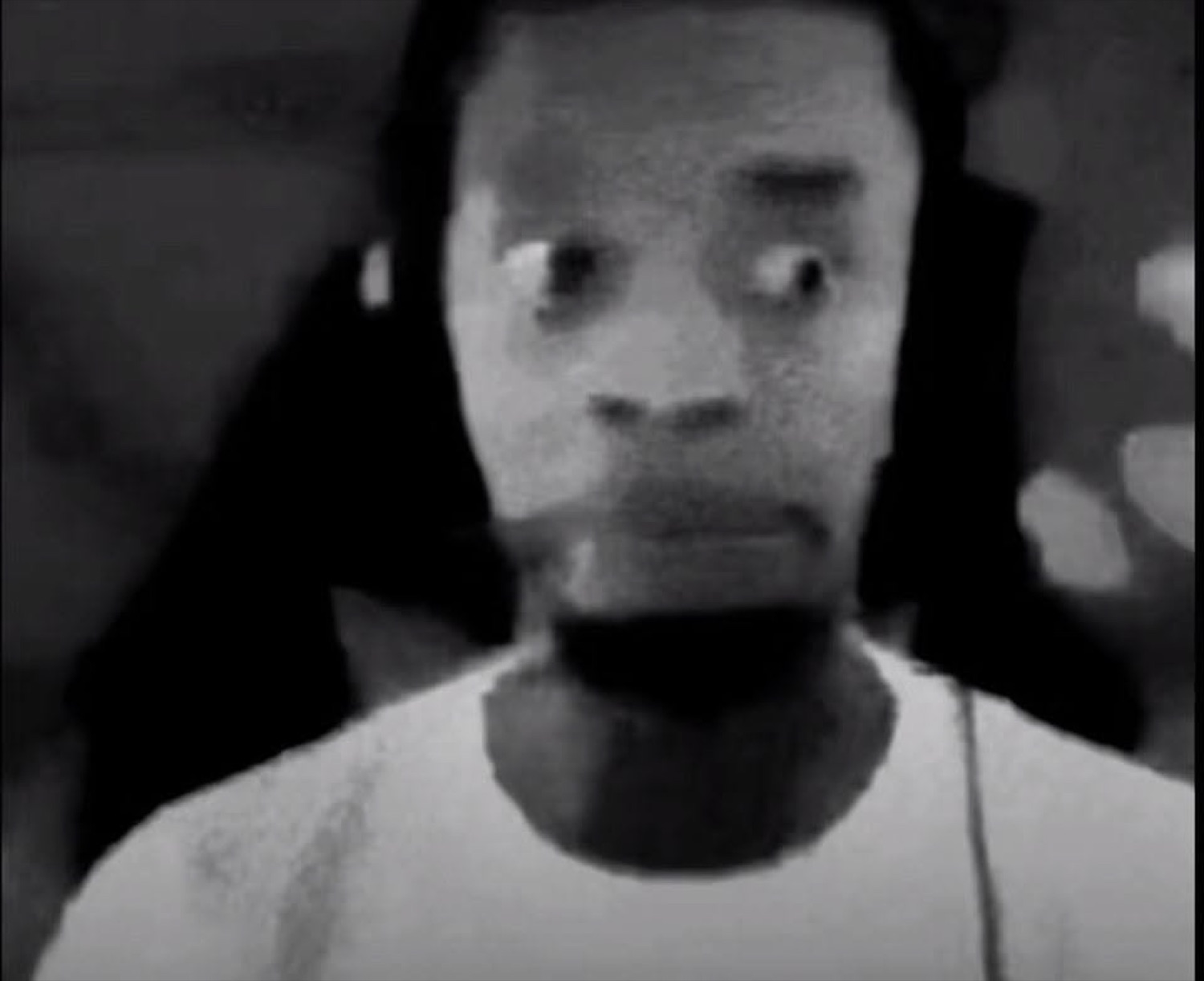 Grainy black-and-white shot of a man with wide, terrified eyes glancing sideways
