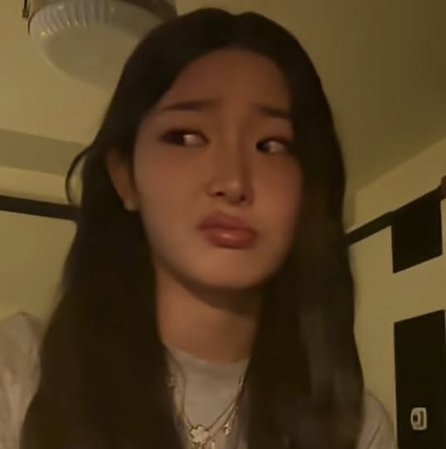 Young woman with long dark hair giving a sideways side-eye look