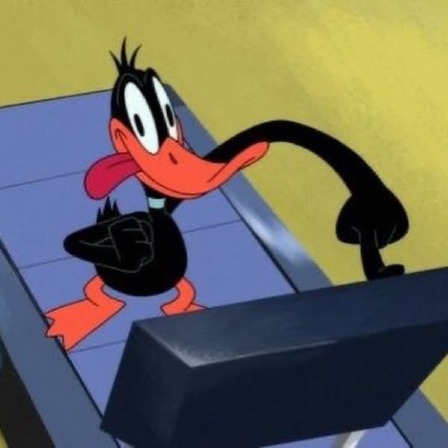 Daffy Duck leaning over a desk with a crafty side-eye expression