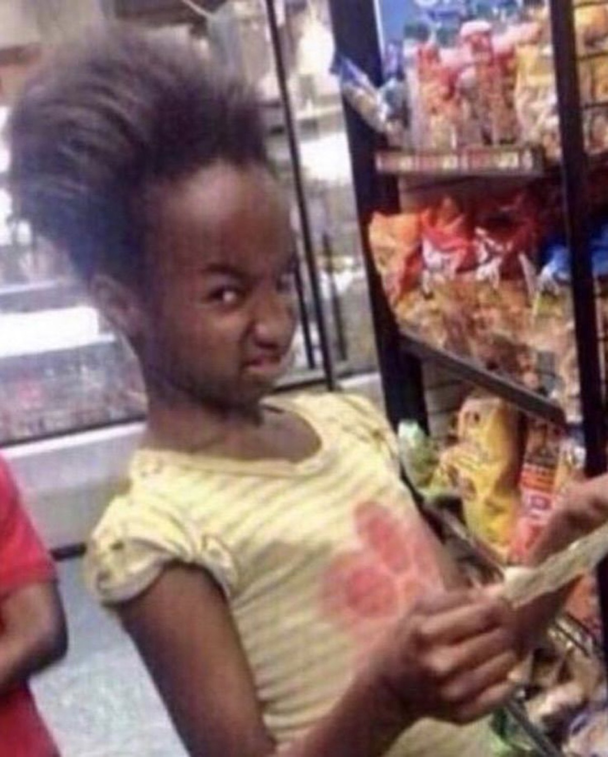 Young girl in a store scrunching her face in a disgusted, judgmental scowl