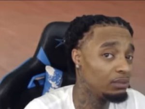 Young man with braided hair in a gaming chair giving a flat, unimpressed side-eye