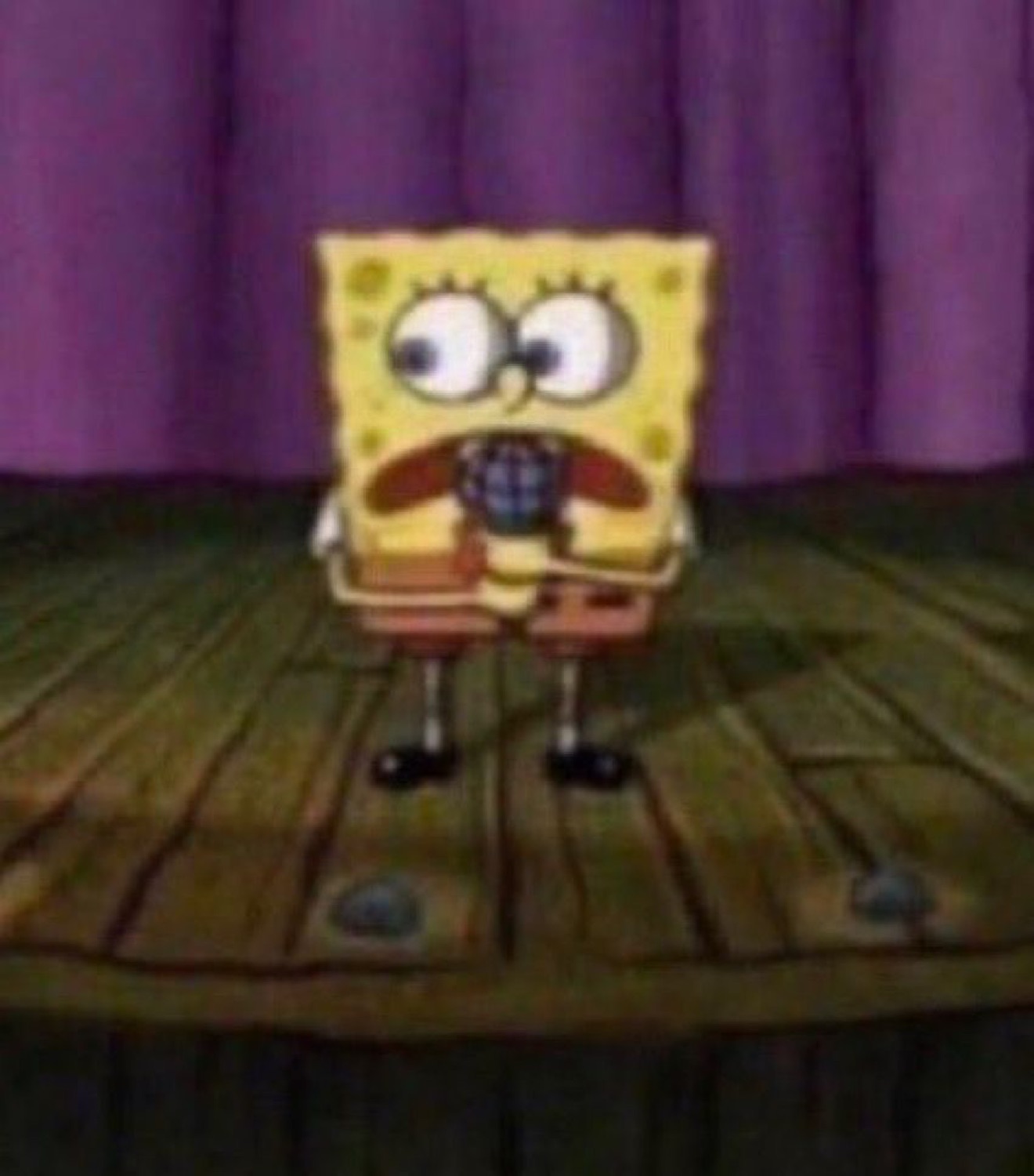 SpongeBob standing on a stage, eyes wide and mouth open in shock