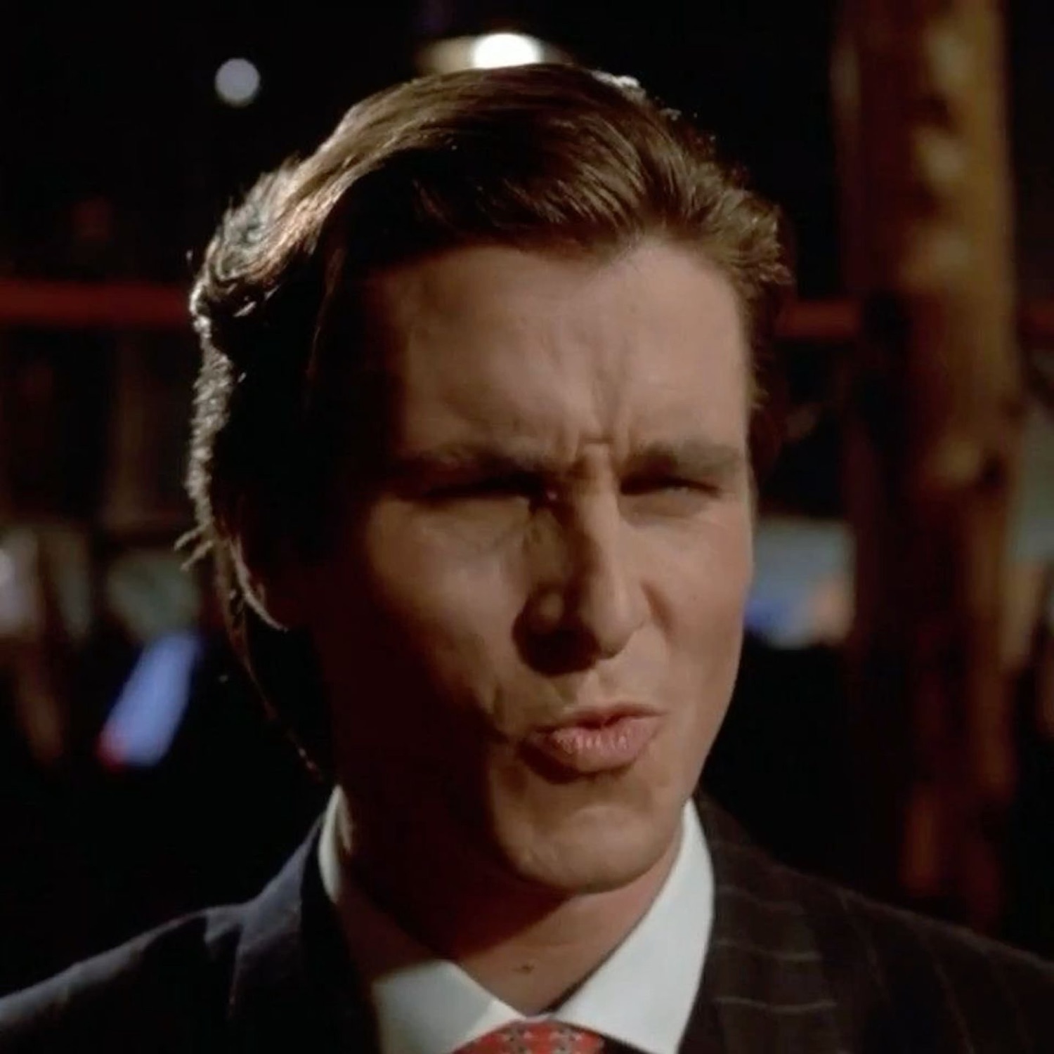 Patrick Bateman squinting with a smug mouth