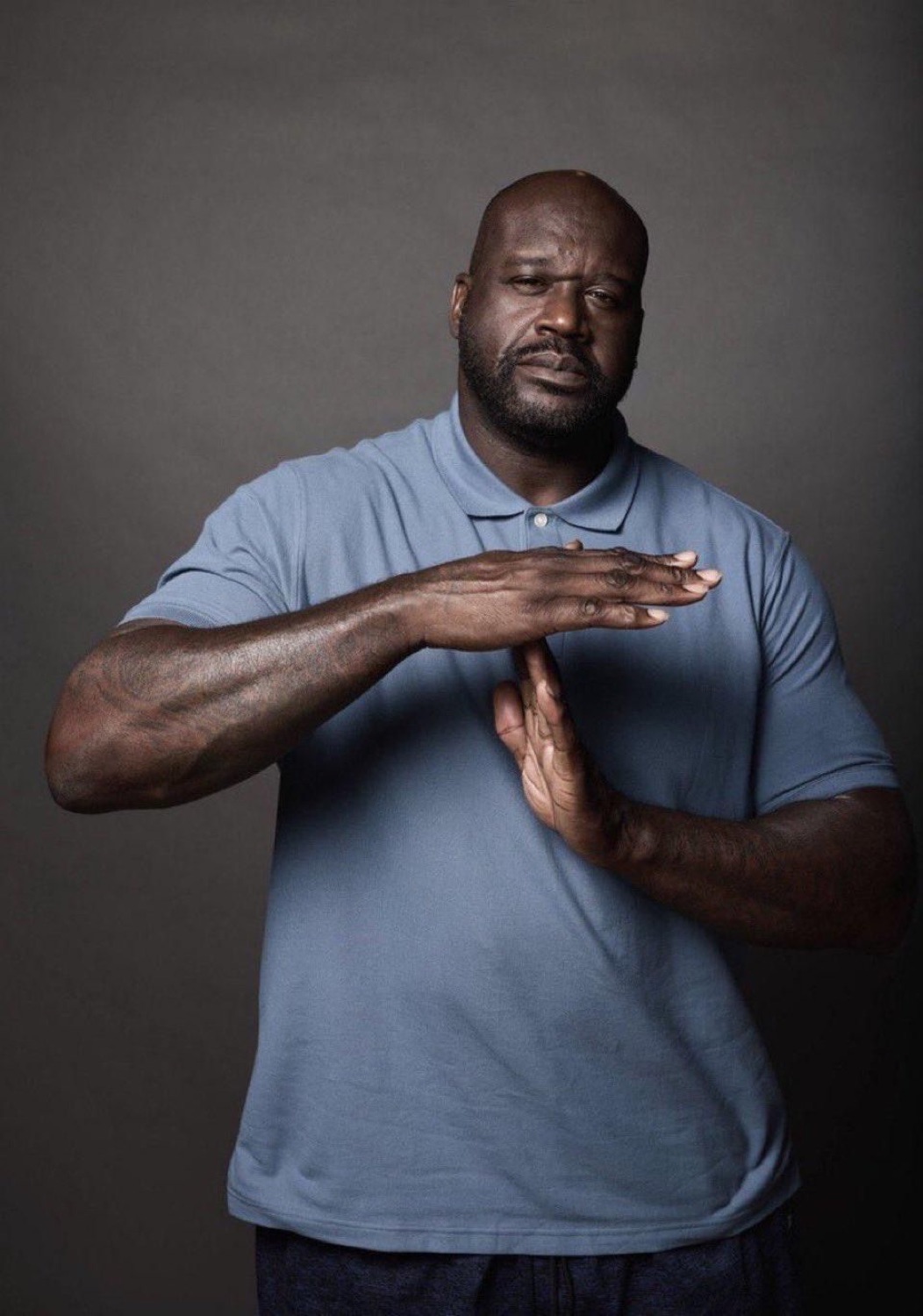 Shaquille O'Neal making a deliberate time-out hand signal with a serious face